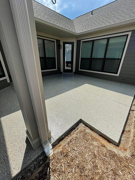 patio floor coating behind black home