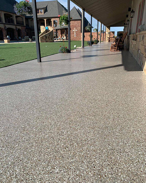 A backyard patio with decorative concrete flooring and walkways